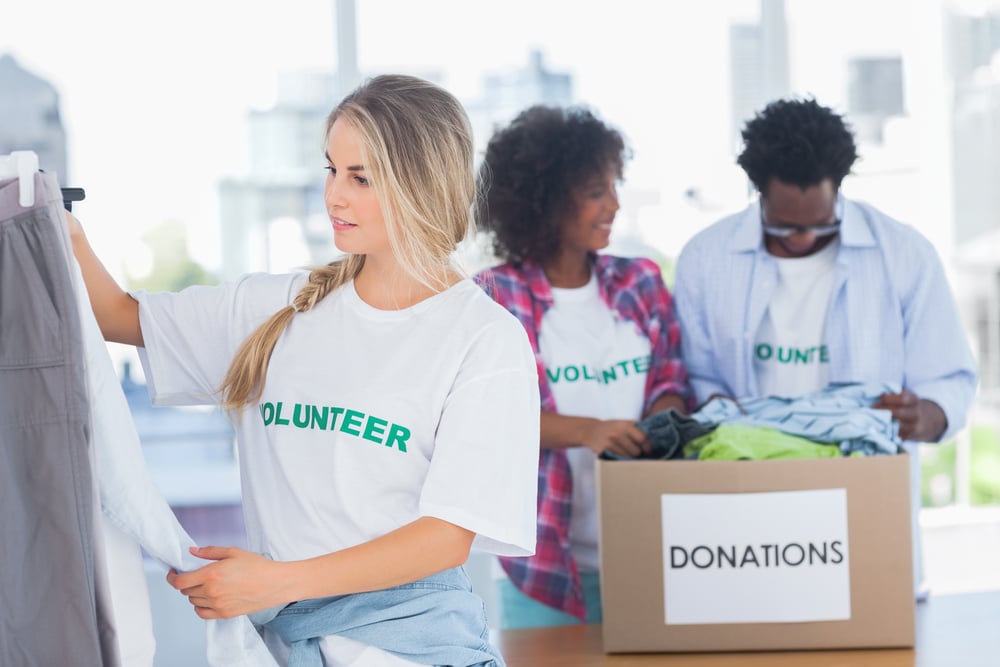 Volunteers putting clothes in clothes rail in their office